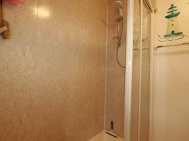 A shower with a curtain and towel rack at Harford