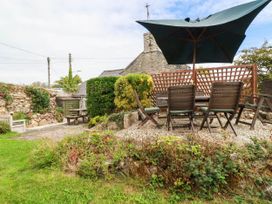 A garden with an outdoor table and chairs under a parasol at Harford