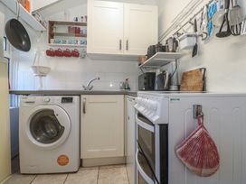 A kitchen with a washing machine and cooking appliances at Harford in Goldsithney