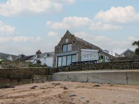 A building with stone walls and outdoor seating at The Boat House - Port Eynon