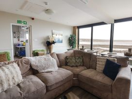 A living room with a sofa and window at The Boat House - Port Eynon