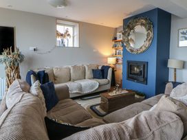 A living room with sofas and a fireplace at The Boat House - Port Eynon