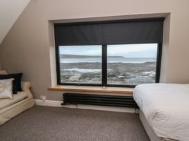 A bedroom with a window overlooking the landscape at The Boat House - Port Eynon
