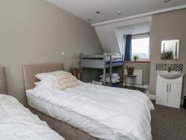 A bedroom with two beds and a bunk bed at The Boat House - Port Eynon