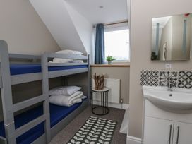 A bedroom with a bunk bed and sink at The Boat House - Port Eynon