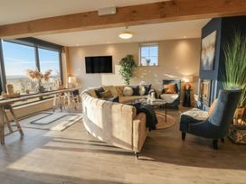A living room with a sofa and armchairs at The Boat House - Port Eynon