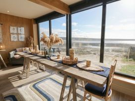 A dining room with a table and chairs at The Boat House - Port Eynon