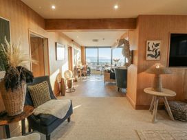 A living room with seating and a table at The Boat House - Port Eynon