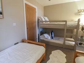 A bedroom with a bunk bed and a single bed at The Boat House - Port Eynon