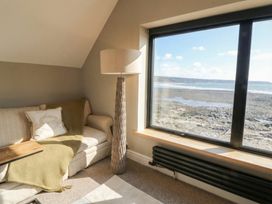 A living room with a sofa and lamp at The Boat House - Port Eynon