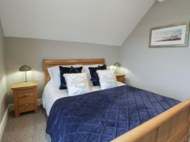 A bedroom with a bed and bedside tables at The Boat House - Port Eynon