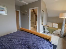 A bedroom with a bed and sofa at The Boat House - Port Eynon