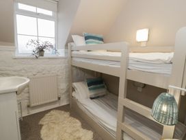 A bedroom with bunk beds and a plant at The Boat House - Port Eynon