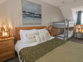A bedroom with a bed and bunk bed at The Boat House - Port Eynon