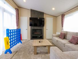 A living room with a sofa and television at Blue Skies in Caernarfon
