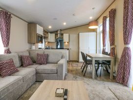 A living room with a sofa and dining area at Blue Skies in Caernarfon