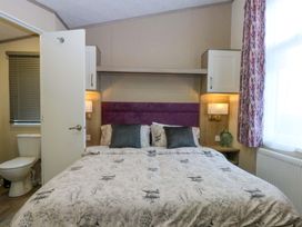 A bedroom with a bed and a toilet at Blue Skies Caernarfon
