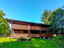 A house with a balcony in a garden at Kinder Lodge (Pet) Fowlis near Dundee