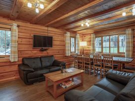 A living room with a sofa and dining area at Kinder Lodge (Pet) Fowlis near Dundee