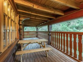 A wooden balcony with a table and chairs at Kinder Lodge (Pet) in Fowlis near Dundee
