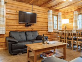 A living room with a sofa and dining area at Kinder Lodge (Pet) Fowlis near Dundee