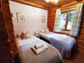 A bedroom with two single beds and a window at Kinder Lodge (Pet) Fowlis near Dundee