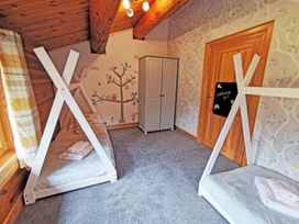 A bedroom with bunk beds and a wardrobe at Kinder Lodge (Pet) Fowlis near Dundee