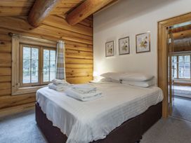 A bedroom with a bed and window at Kinder Lodge (Pet) Fowlis near Dundee