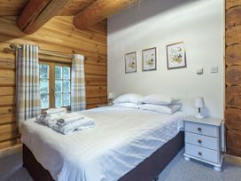 A bedroom with a bed and bedside table at Kinder Lodge (Pet) Fowlis near Dundee