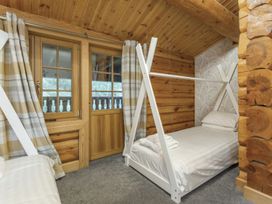 A bedroom with a bunk bed and single bed at Kinder Lodge (Pet) Fowlis near Dundee