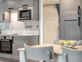 A kitchen with appliances and a table with a bowl of apples at St Ives Studio in Praze-An-Beeble