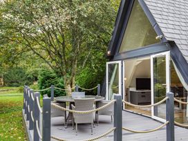 An outdoor deck with a table and chairs at St Ives Studio in Praze-An-Beeble