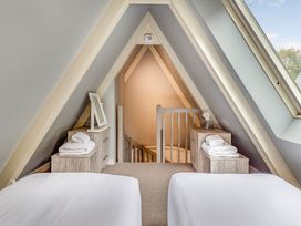 A bedroom with two beds and a staircase at St Ives Studio in Praze-An-Beeble