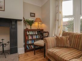 A living room with a bookshelf and a sofa at The Manse in Whitby