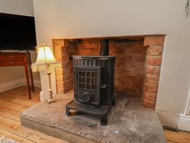 A living room with a stove and television at The Manse in Whitby