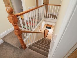 A staircase with a handrail and wooden door at The Manse in Whitby