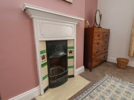 A bedroom with a fireplace and a chest of drawers at The Manse in Whitby