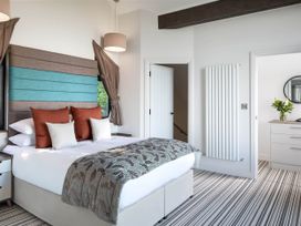 A bedroom with a bed and wardrobe at Ferry Hills in Laugharne