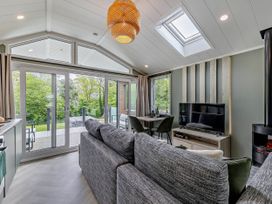 A living room with a sofa and dining area at Prion Spa, Llandyrnog