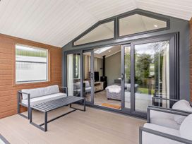A conservatory with seating and an open view at Prion Spa in Llandyrnog