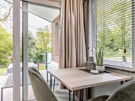 A dining area with a table and chairs near a window at Prion Spa Llandyrnog