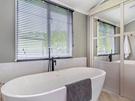 A bathroom with a bathtub and sink at Prion Spa in Llandyrnog