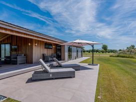 A patio with lounge chairs and an umbrella at Darwin Retreat in Wigton