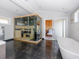 A bathroom with a sauna and bathtub at Darwin Retreat in Wigton