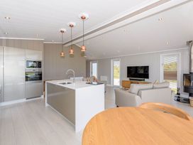 A kitchen with an island, oven, and seating area at Darwin Retreat in Wigton