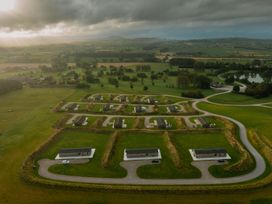 An aerial view of a cluster of buildings and greenery at Darwin Retreat in Aspatria