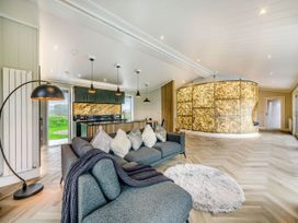 A living room with a sofa and kitchen area at The Sheraton Retreat in Wigton
