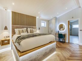 A bedroom with a bed and wardrobe at The Sheraton Retreat in Wigton