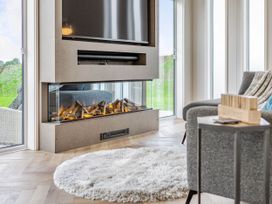 A living room with a fireplace and television at The Sheraton Retreat in Wigton