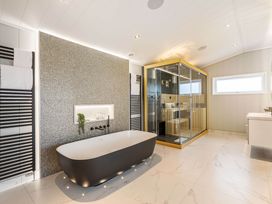 A bathroom with a bathtub and shower enclosure at The Sheraton Retreat in Wigton